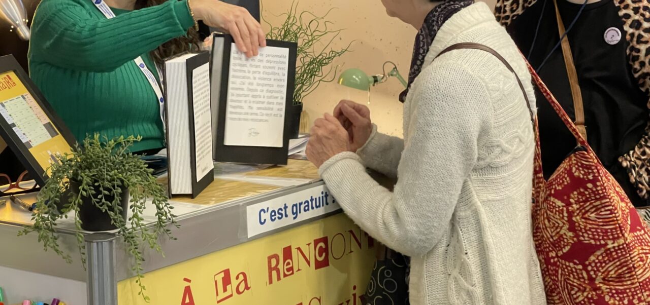 Veronica au Kiosque de l AQRP au Salon du livre de Montreal 2024 avec des visiteurs curieux 1 1